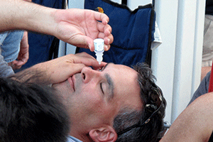 man taking eyedrops - forbes opticians, hadleigh, essex